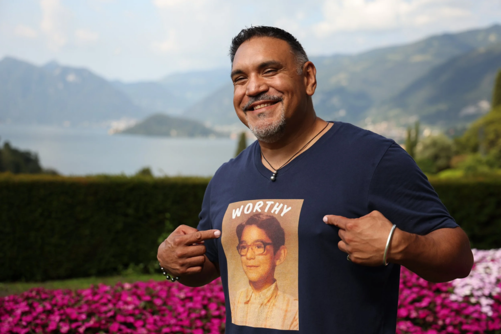 Author Jesse Leon wears a t-shirt of him as a youth with the word "worthy" above his image