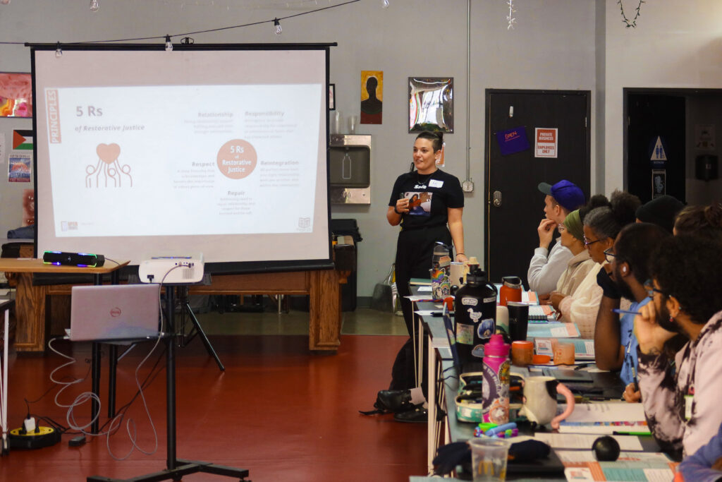 Action shot of Open Doors facilitator Kat Besse training the staff of Waking the Village in Sacramento