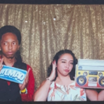 Mentee Donald and Mentor Alina at a photobooth doing a silly pose