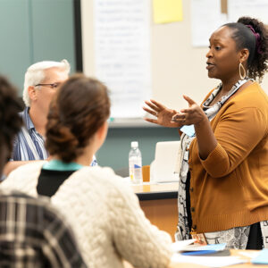 Teacher leading a diverse group of adults in an engaging classroom discussion